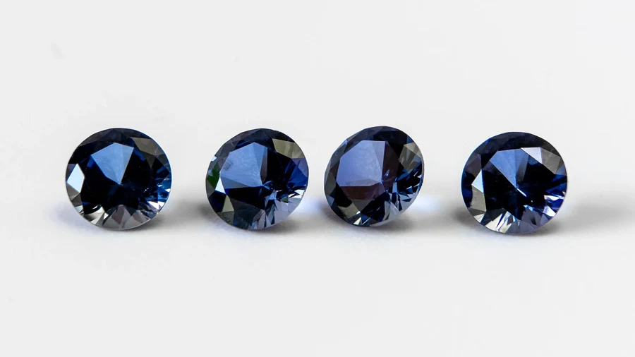 Quatre saphirs bleus de synthèse taillés en rond sur fond blanc