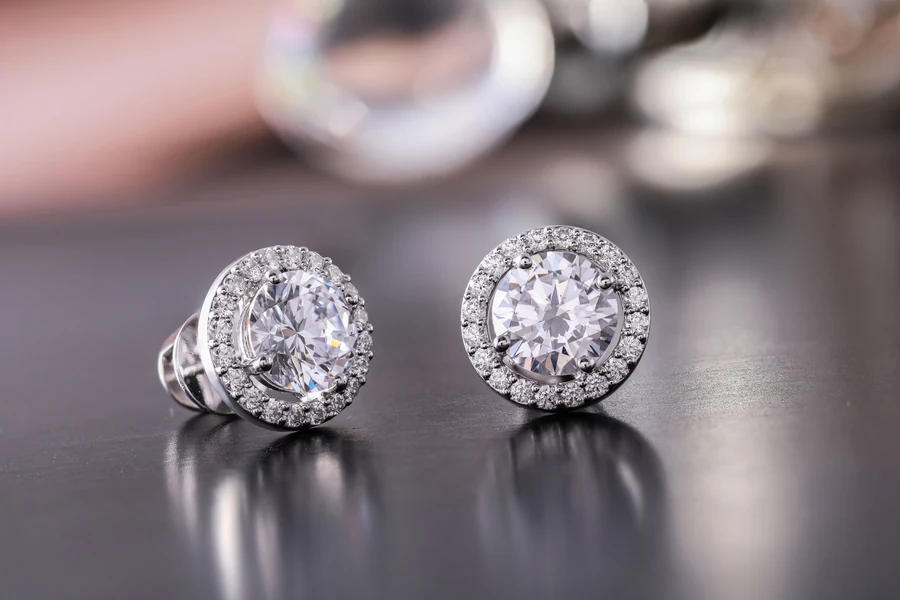 Paire de boucles d'oreilles puces serties de pierres blanches, tige et poussette visibles à l'arrière